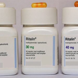 Ritalin medication containers labelled with different milligram strengths, with several tablets placed beside them on a clean surface. Ritalin For Sale Australia